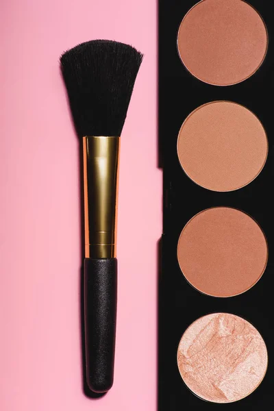 Top view of bronzer palette with brush on pink surface — Stock Photo