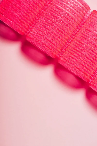 Vue de dessus des bigoudis roux en rangée sur la surface rose — Photo de stock