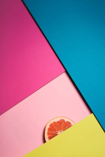 Vista dall'alto di fetta di pompelmo su superfici colorate — Foto stock