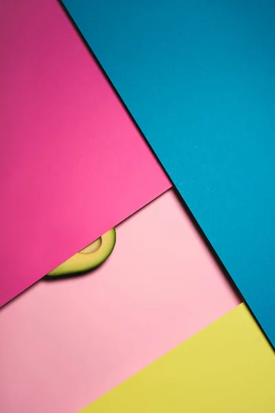 Top view of half of avocado on colorful surfaces — Stock Photo