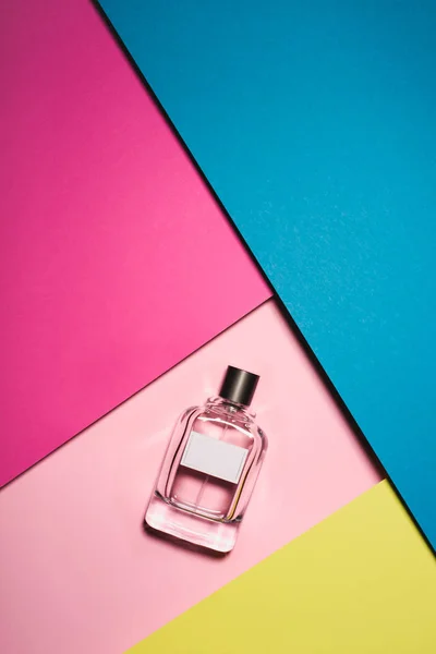 Top view of glass bottle of perfume on colorful surface — Stock Photo