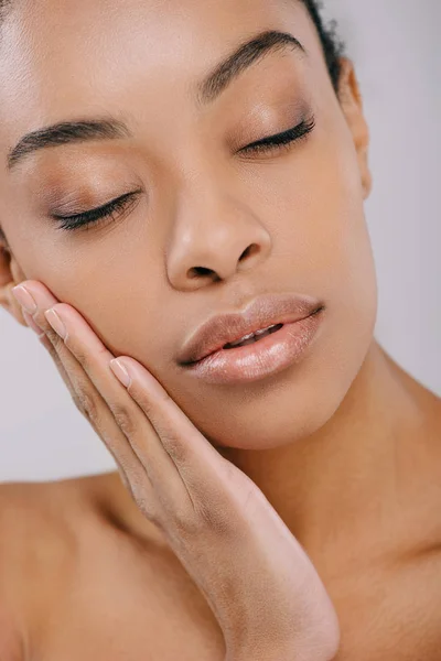 Femme africaine américaine sensuelle avec une peau parfaite touchant son visage isolé sur gris — Photo de stock