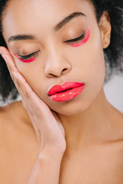 Sensual african american woman with red lips and red paint strokes under eyes isolated on grey — Stock Photo