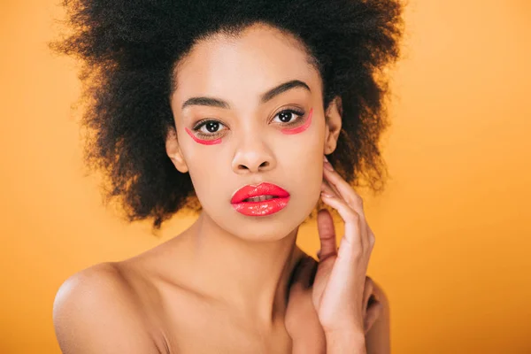 Atractiva joven con maquillaje rojo creativo y peinado afro aislado en amarillo - foto de stock