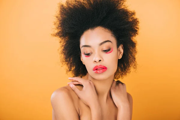 Hermosa joven con maquillaje rojo creativo y peinado afro aislado en amarillo - foto de stock