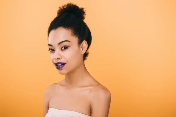 Jeune femme souriante aux lèvres violettes isolées sur jaune — Photo de stock