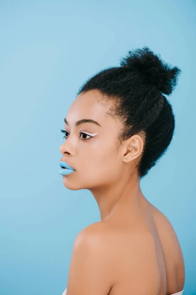 Attrayant jeune femme avec maquillage créatif regardant loin isolé sur bleu — Photo de stock