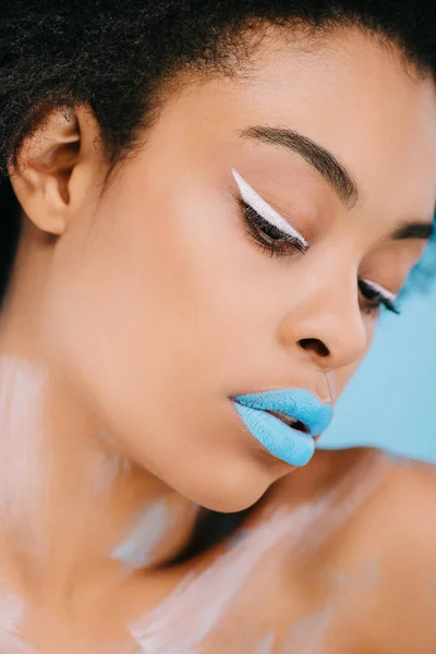 Primer plano retrato de mujer joven con maquillaje creativo y la piel perfecta en azul - foto de stock