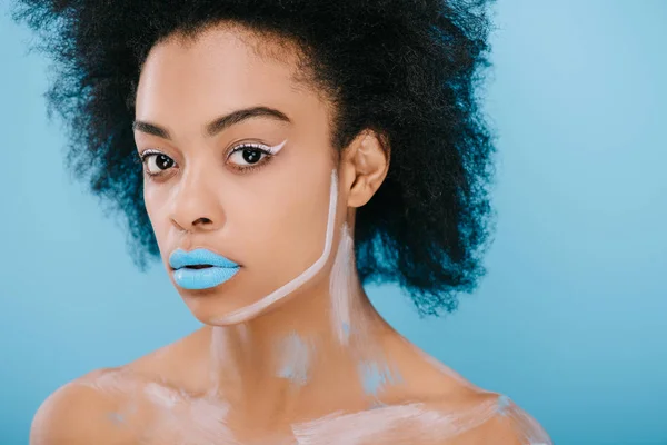 Atractiva joven con maquillaje creativo y peinado afro aislado en azul - foto de stock