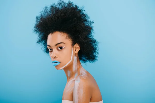 Beautiful young woman with creative makeup and afro hairstyle isolated on blue — Stock Photo