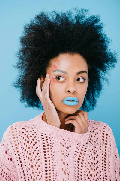 Schöne junge Frau mit kreativem Make-up im Pullover auf blau — Stockfoto