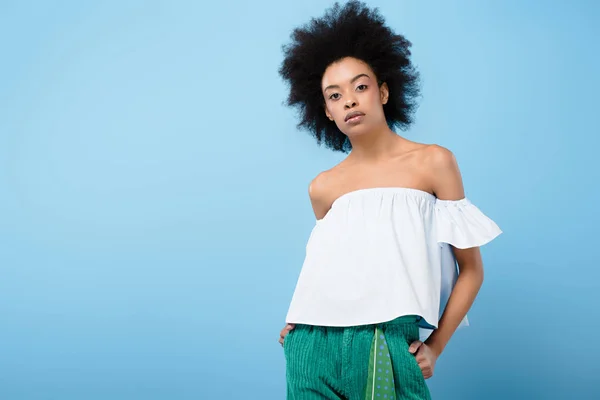 Beautiful african american woman in fashionable off-the-shoulder top isolated on blue — Stock Photo