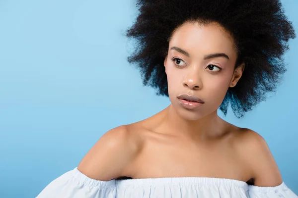 Retrato de cerca de la mujer afroamericana en la parte superior elegante fuera del hombro aislado en azul - foto de stock