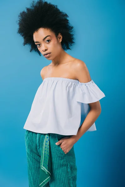 Young african american woman in stylish off-the-shoulder top isolated on blue — Stock Photo