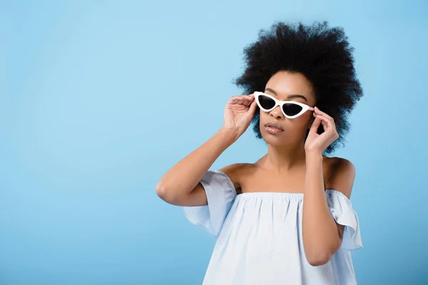 Attrayant jeune femme dans des lunettes de soleil rétro élégant isolé sur bleu — Photo de stock