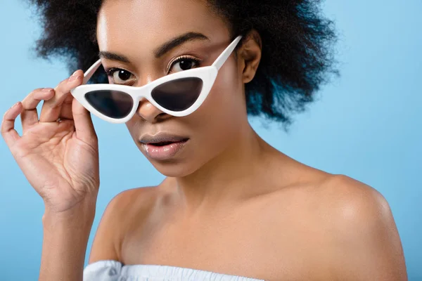 Retrato de cerca de la hermosa mujer joven en gafas de sol retro con estilo aislado en azul - foto de stock