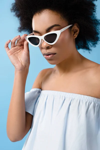 Belle jeune femme dans des lunettes de soleil rétro élégant isolé sur bleu — Photo de stock