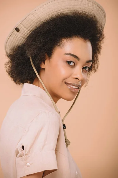 Ritratto ravvicinato di donna afro-americana felice con cappello safari isolato sul beige — Foto stock