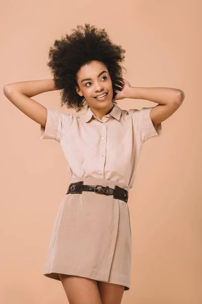 Mujer joven feliz en ropa elegante aislado en beige - foto de stock