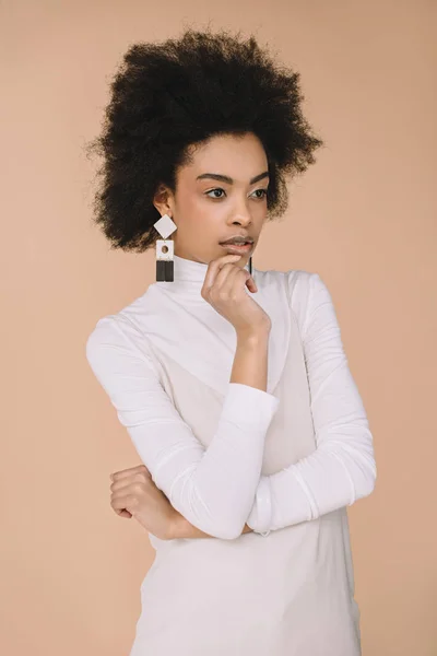 Attractive young woman in white turtleneck and dress isolated on beige — Stock Photo