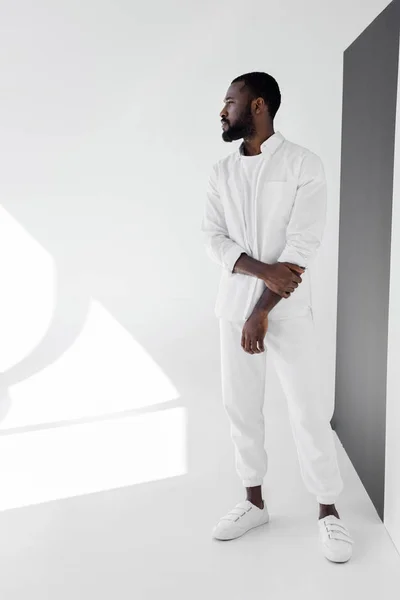 Handsome african american man in white trendy clothes looking away — Stock Photo