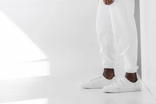 Imagem cortada de homem americano africano elegante em roupas brancas e gumshoes no branco — Fotografia de Stock