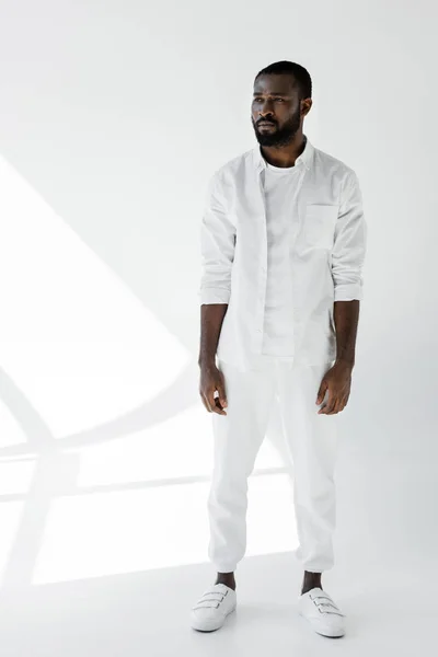 Handsome stylish african american man standing in white clothes on white — Stock Photo