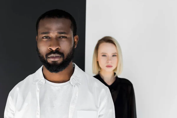 Multikulturelles Paar blickt in die Kamera in der Nähe einer schwarz-weißen Wand, Yin Yang Konzept — Stockfoto
