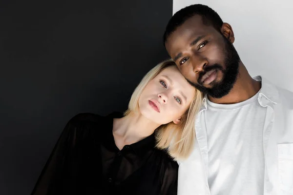 Afrikanisch-amerikanischer Freund und blonde Freundin umarmen sich und schauen in die Kamera — Stockfoto