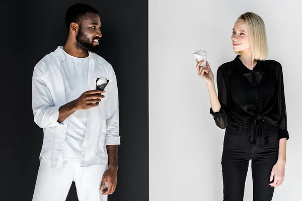 Multicultural couple looking at each other with ice cream cones, yin yang concept — Stock Photo