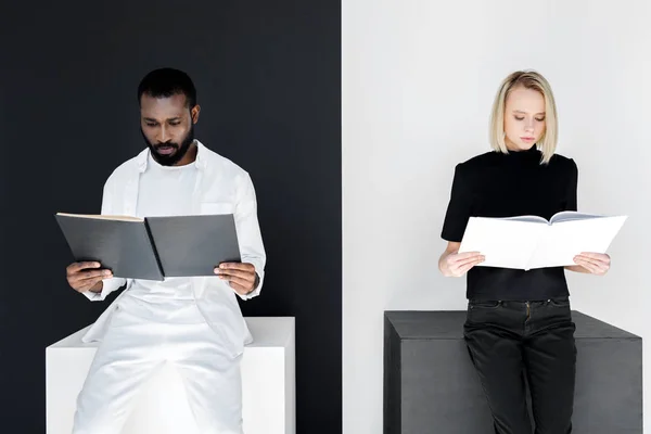 Multicultural couple reading black and white books, yin yang concept — Stock Photo