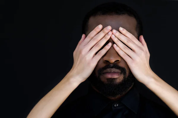 Image recadrée de petite amie fermer les yeux du petit ami afro-américain isolé sur noir — Photo de stock