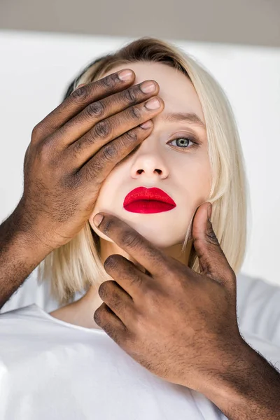 Image recadrée de copain afro-américain touchant visage de petite amie blonde avec les mains — Photo de stock