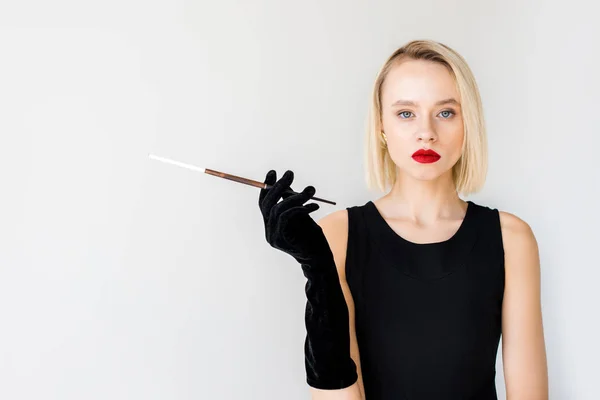 Attractive stylish blonde woman in black dress holding cigarette isolated on white — Stock Photo