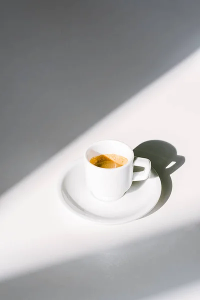 Tazza di caffè saporito in tazza bianca su superficie bianca — Foto stock