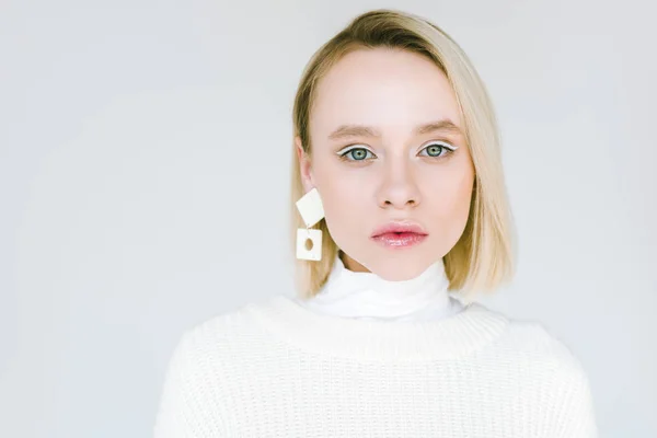 Retrato de hermosa mujer rubia con estilo con maquillaje y pendiente aislado en blanco - foto de stock