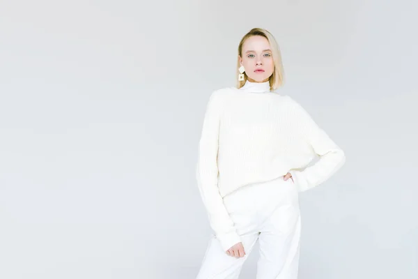 Schöne modische blonde Frau in weißen Kleidern schaut in die Kamera isoliert auf weiß — Stockfoto