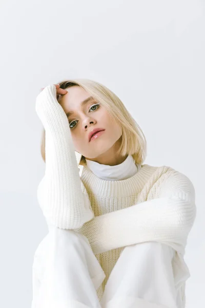 Портрет привабливої модної блондинки в білому одязі дивиться на камеру ізольовано на білому — стокове фото