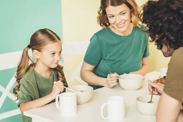 Recortado disparo de feliz joven familia desayunando juntos - foto de stock