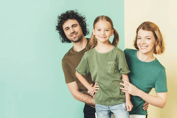 Familia feliz con un niño usando camisetas y sonriendo a la cámara - foto de stock