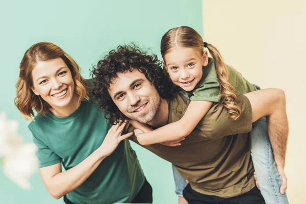 Familia feliz con un niño divirtiéndose juntos y sonriendo a la cámara - foto de stock