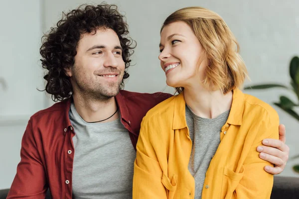 Beau jeune couple heureux embrassant et souriant à la maison — Photo de stock