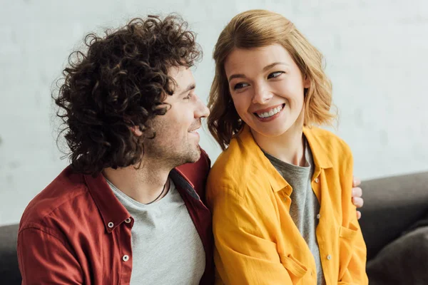 Belo feliz jovem casal sorrindo uns aos outros em casa — Fotografia de Stock