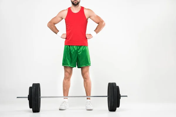 Cropped view of sportsman in retro sportswear standing near barbell, isolated on white — Stock Photo