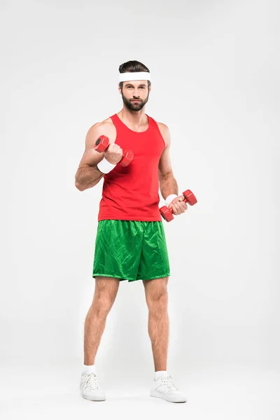 Apuesto deportista en entrenamiento de ropa deportiva retro con mancuernas, aislado en blanco - foto de stock