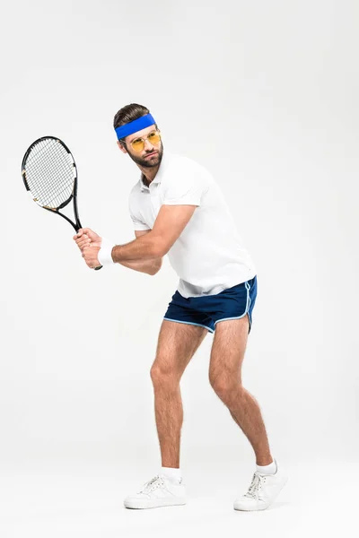 Jugador de tenis en gafas de sol retro de entrenamiento con raqueta, aislado en blanco - foto de stock