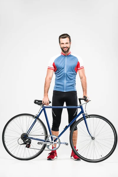 Gut aussehender, gut gelaunter Radfahrer in Sportkleidung, der mit Fahrrad posiert, isoliert auf weiß — Stockfoto