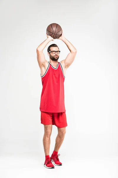 Sportif en tenue de sport rouge et lunettes rétro jouant au basket, isolé sur blanc — Photo de stock