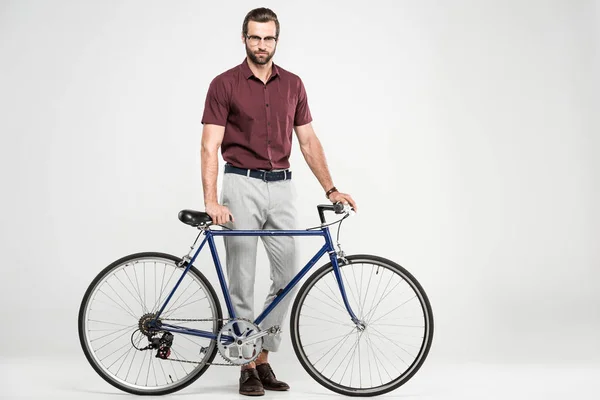 Homem elegante posando com bicicleta, isolado em cinza — Fotografia de Stock