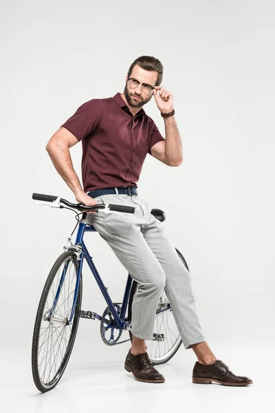 Елегантний чоловік позує з велосипедом, ізольований на сірому — стокове фото